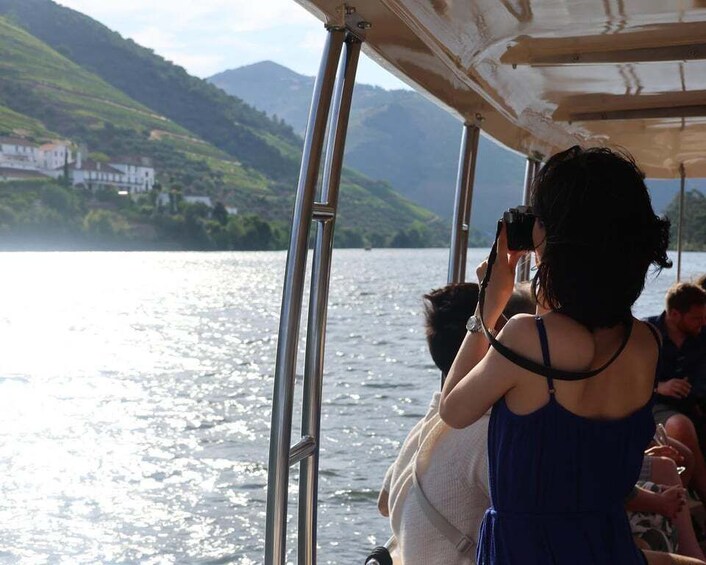 A boat with people on board, a lake, and hills in the background. 2