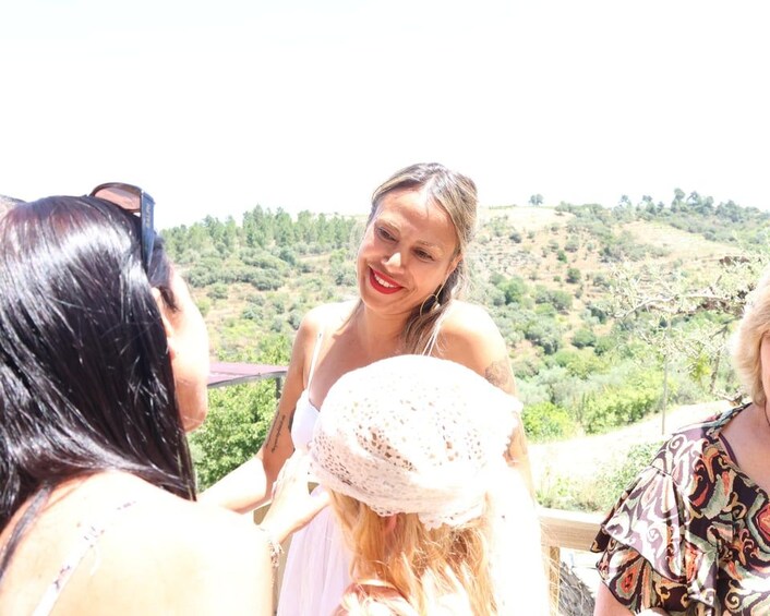 A group of people on a balcony overlooking a hilly landscape. 5