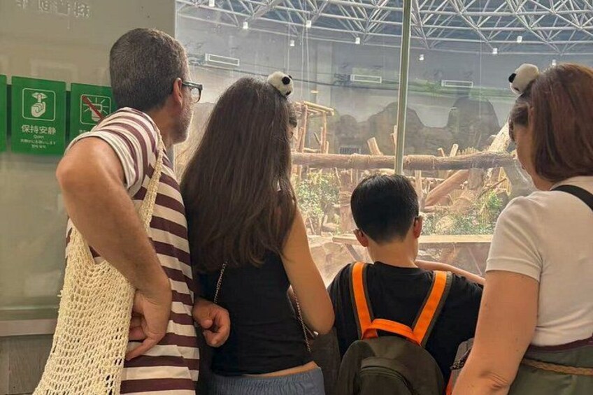 A group of people observing an exhibit through a glass enclosure. 3