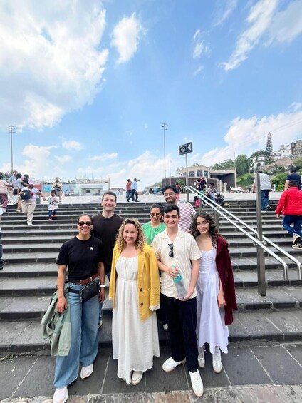 A group of people standing on stone steps with a building labeled 'SAUTERERIO' in the background. 4