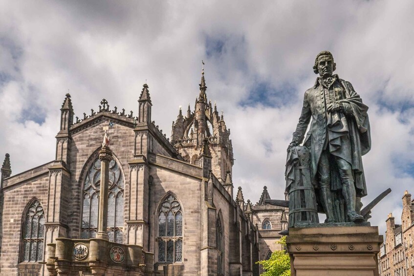 Eine gotische Kirche mit filigraner Architektur und einer Statue einer historischen Persönlichkeit. 4