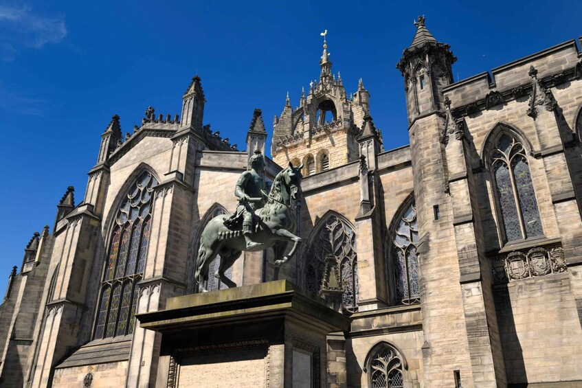 Ein historisches Gebäude mit aufwendiger Architektur, darunter eine markante Statue eines Ritters zu Pferd und filigranes Mauerwerk. 2