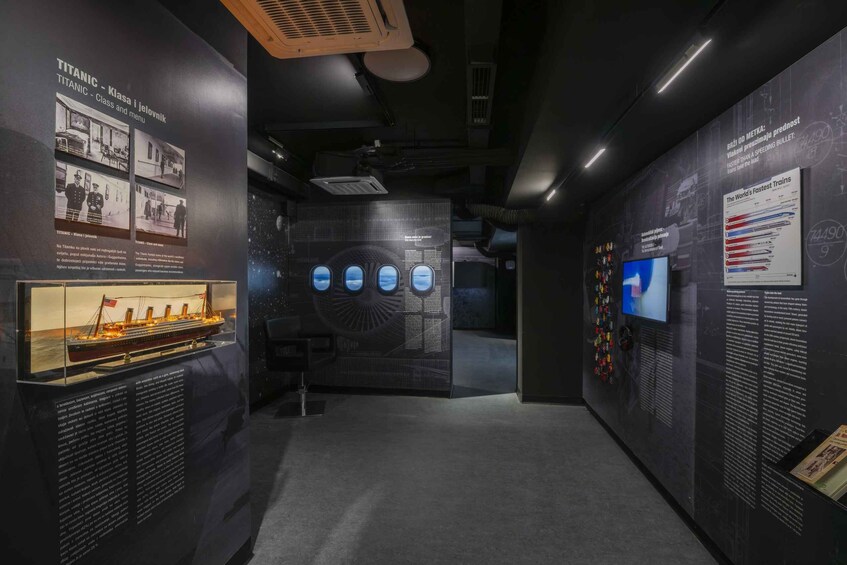 An exhibit about the Titanic with a model ship, informational panels, and a large display of the ship's windows. 4