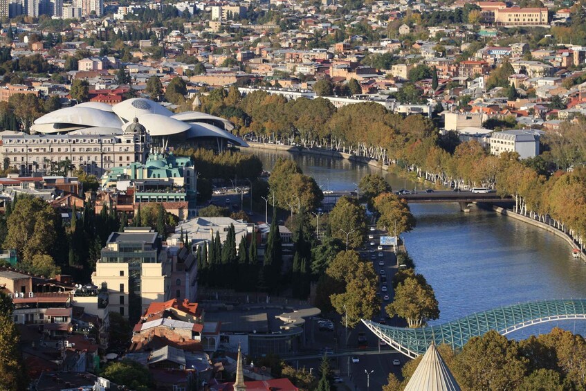 A cityscape with a river, a bridge, and distinctive modern architecture including a large dome-shaped building. 5