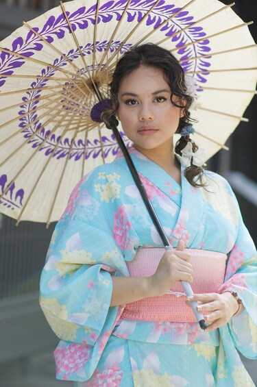 A person in a kimono holding a fan with a floral pattern. 5