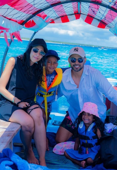 A group of people on a boat with a canopy overhead. 2