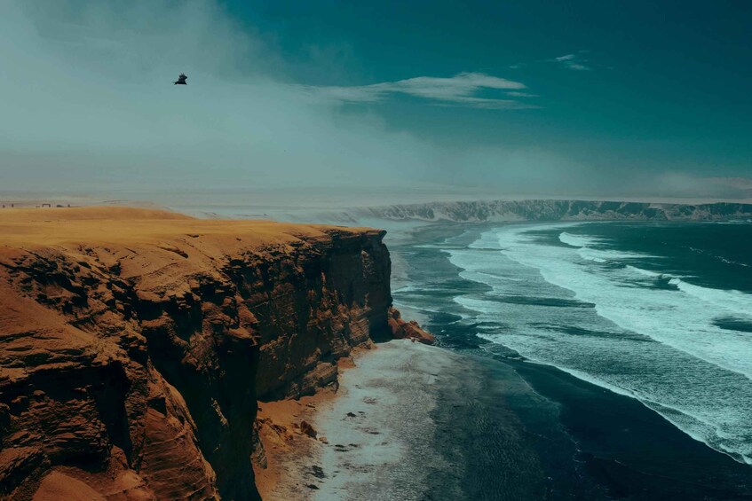 A coastal cliff with waves crashing below. 2