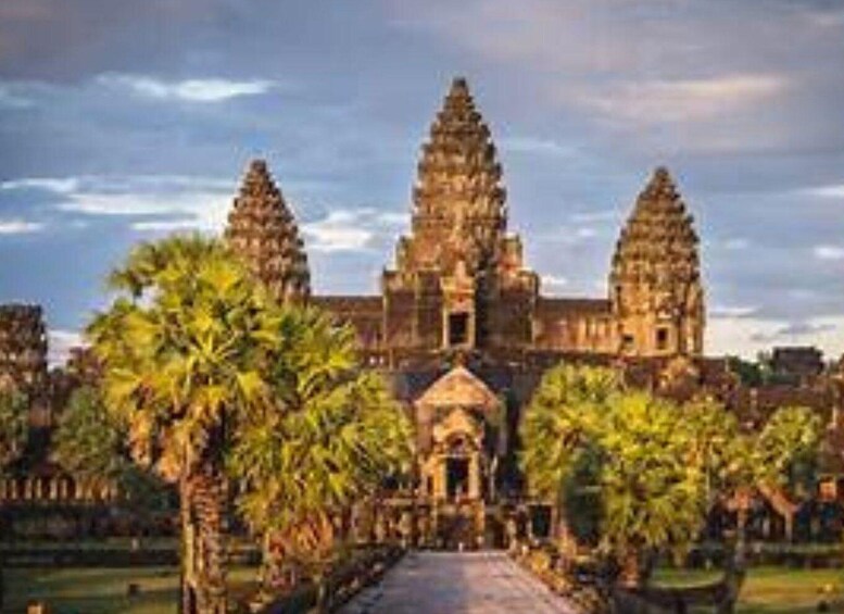 A temple with three towers, surrounded by palm trees and a paved pathway. 2