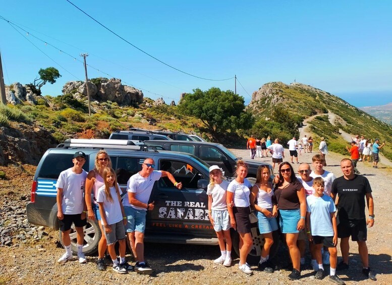 A group of people posing in front of a vehicle with a sign that reads 'The Real Safari' and 'Feel Like a Continent.' 4