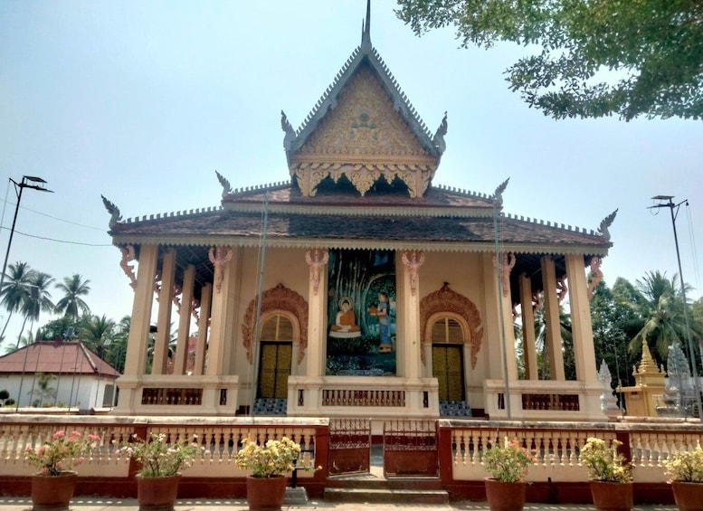 A traditional temple with a pointed roof, ornate decorations, and a central mural. 5