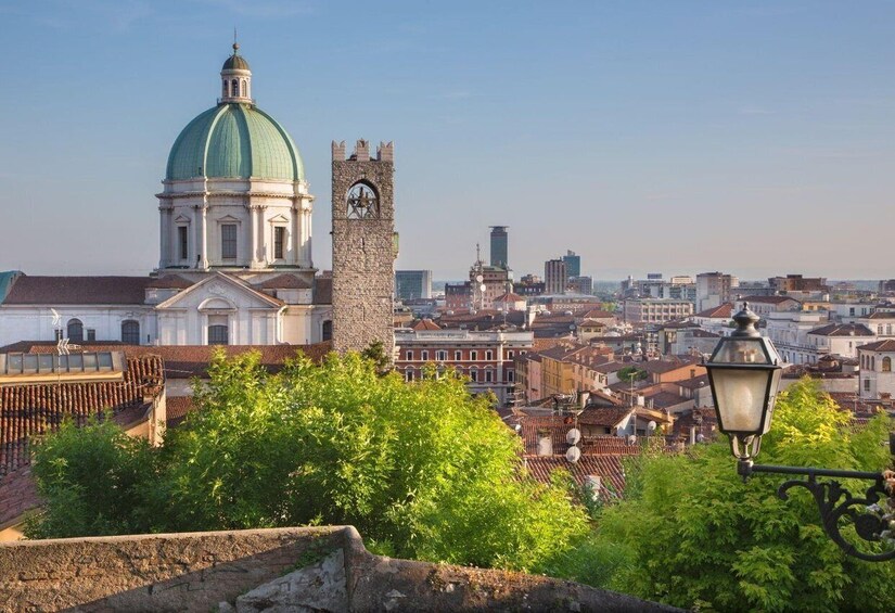 A historic cityscape with a prominent church dome, a clock tower, and a mix of traditional and modern buildings. 3