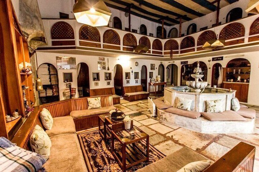 A spacious courtyard with a fountain, seating areas, and arched walkways. 1