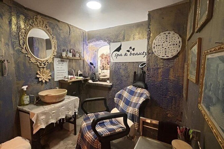 A spa and beauty salon interior with a vintage aesthetic, including a wooden basin, a mirror, and a chair with a plaid cover. 4