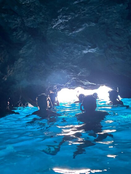A cave with water inside, illuminated by natural light. 4