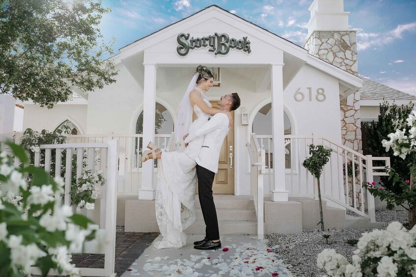 A couple embracing in front of a white building with the sign "StoryBook" and the number "618". 1