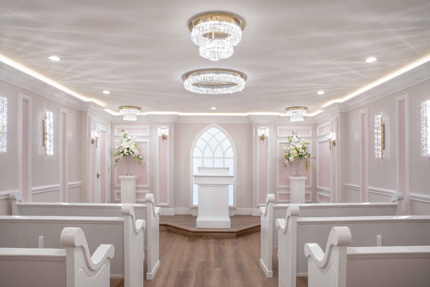 An elegant church interior with pews, chandeliers, and floral decorations. 3