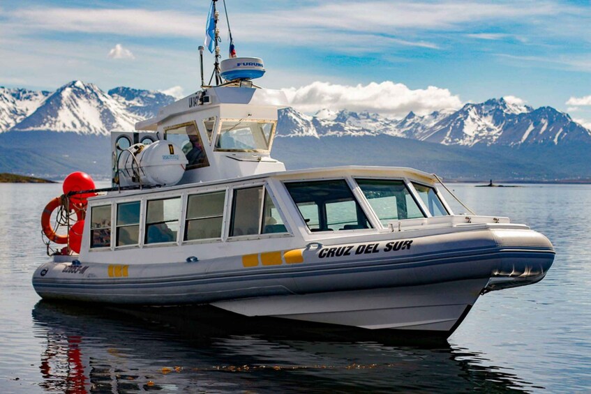 A boat named 'CRUZ DEL SUR' on calm waters with a mountainous backdrop. 2