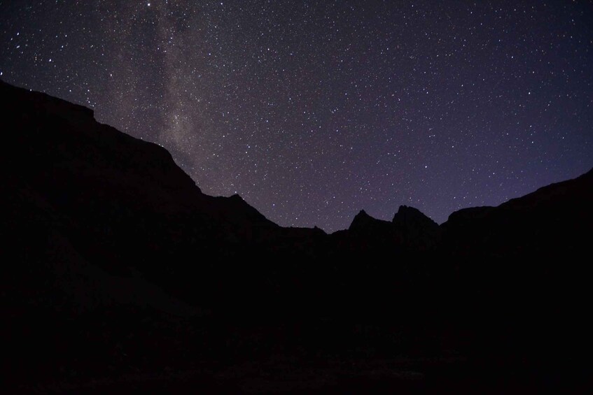 A starry night sky over a mountainous landscape. 4