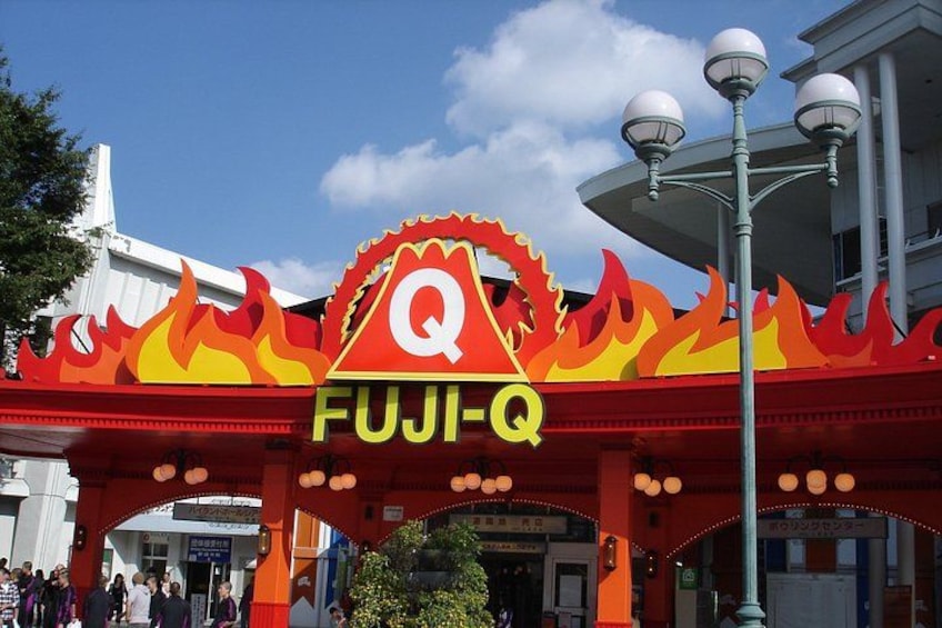 Ein rotes und gelbes Schild mit den Buchstaben 'Q' und 'FUJI-Q' auf einer Brücke. 3