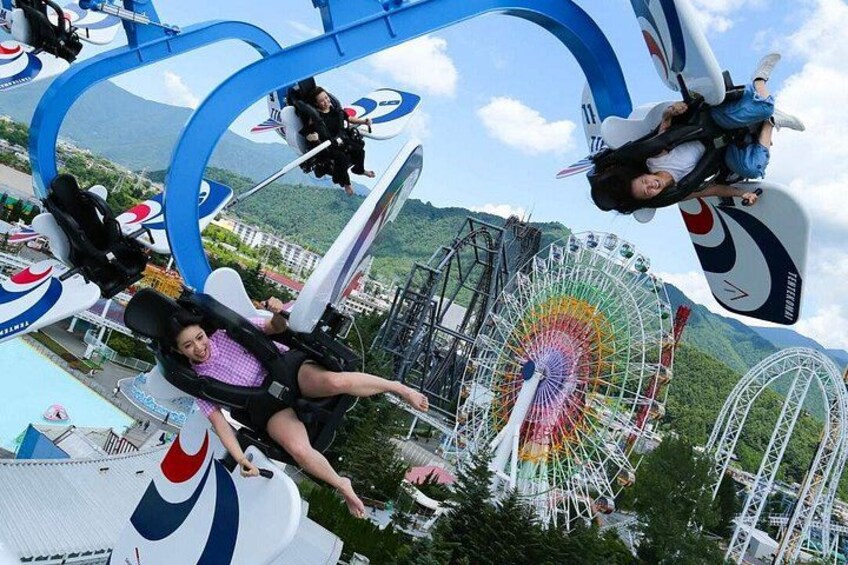 Eine Achterbahn mit einem Riesenrad im Hintergrund. 2