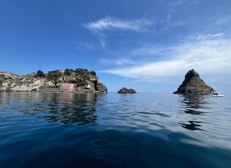 A coastal landscape with rocky outcrops, calm waters, and a small boat. 3