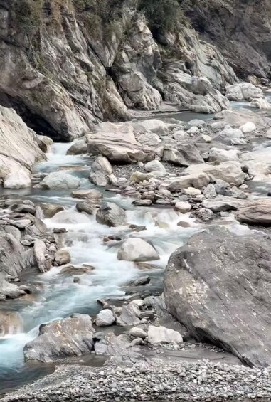 A rocky riverbed with flowing water and large boulders. 2