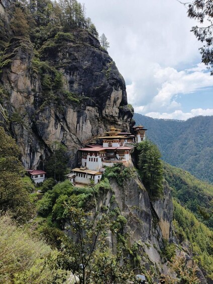 Un monastère perché sur une falaise, composé de plusieurs bâtiments. 1