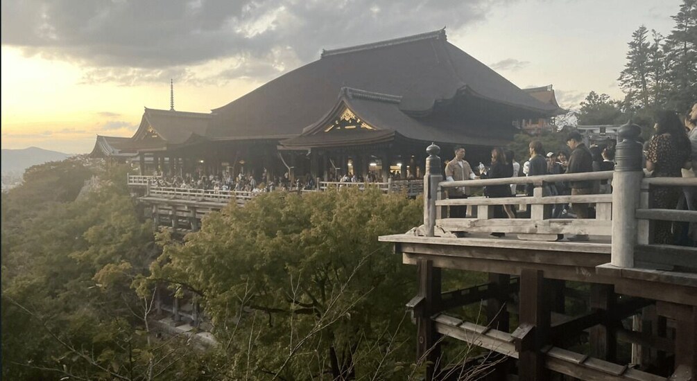 A traditional building with a steep roof, surrounded by lush greenery and a wooden viewing platform. 4