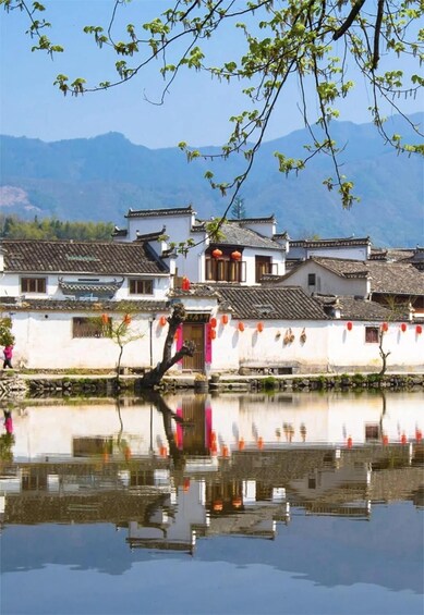 A traditional Chinese village with white buildings, red lanterns, and a calm river reflecting the scenery. 3