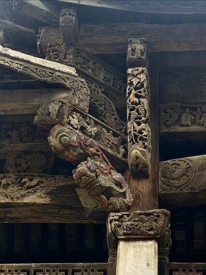 A detailed carved wooden structure with intricate designs and figures. 4