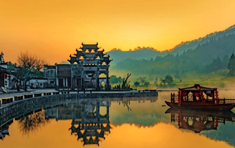 A traditional Chinese building with a reflection in the water, a boat, and a mountainous landscape in the background. 2