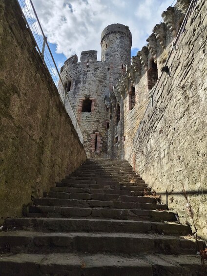 A stone staircase leading to a castle with a round tower. 3