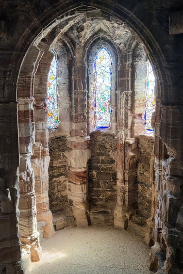 A stone archway with three stained glass windows. 5