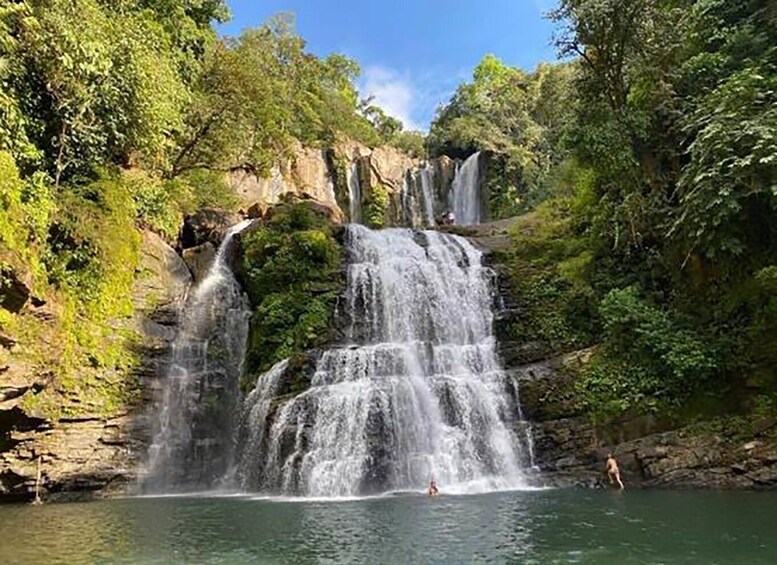 A multi-tiered waterfall surrounded by lush greenery. 3