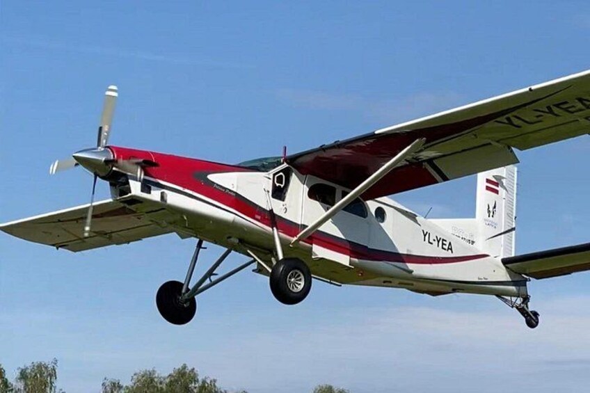 A small aircraft with the registration number YL-YEA in flight. 3