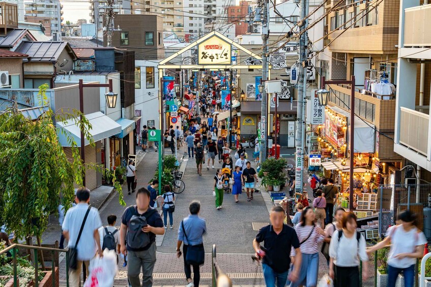 A bustling street market with people walking and vendors selling goods. 1