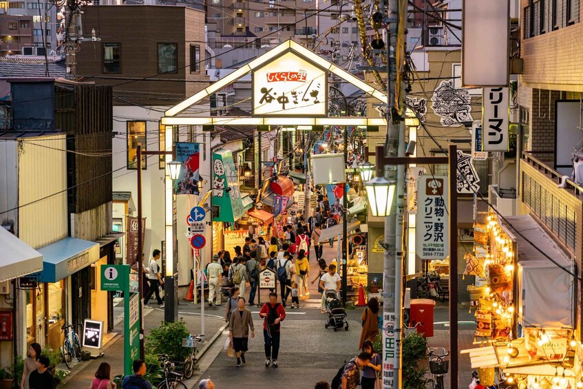 A bustling street market with people walking and shops on either side. 2
