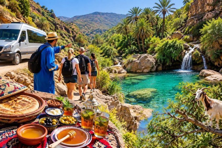 A group of people hiking near a waterfall, with a table of food and drinks. 5