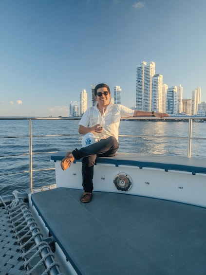 Una persona sentada en la cubierta de un barco con un horizonte urbano al fondo. 4