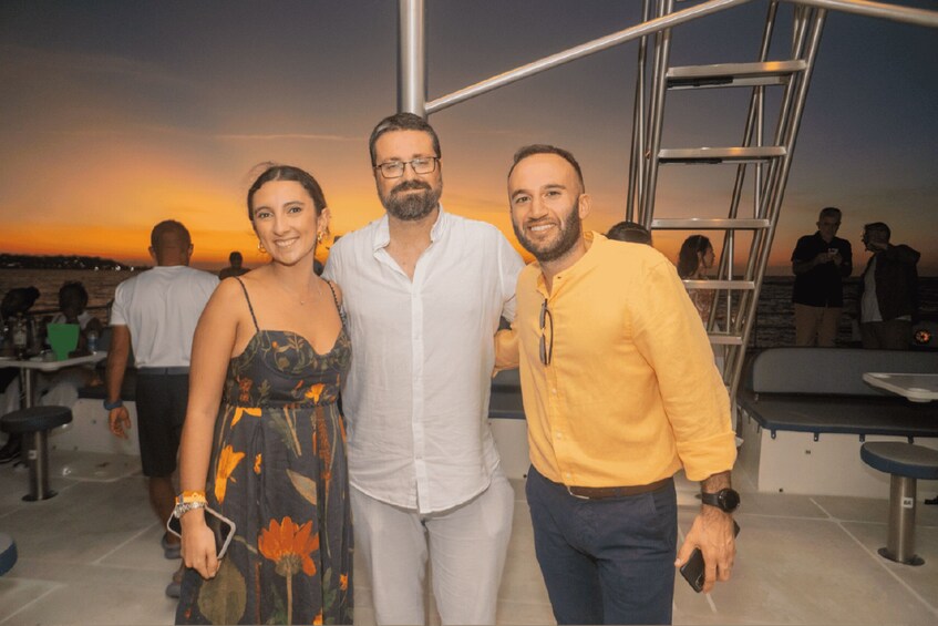Un grupo de personas en un barco con un atardecer de fondo. 2