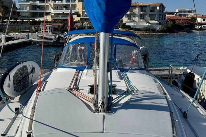 A boat docked at a marina with buildings in the background. 2