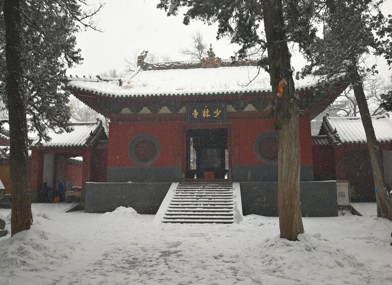 A traditional building with a red facade and a snow-covered roof. 5