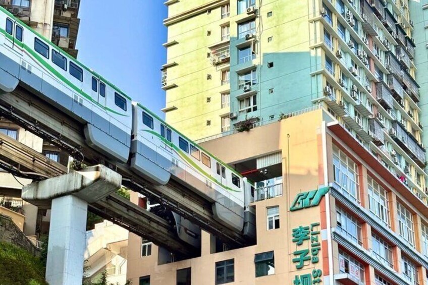 A train on an elevated track above a cityscape with high-rise buildings. 1