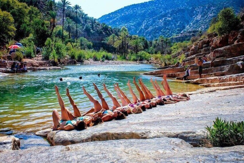 Un río con gente tomando el sol sobre rocas y un cielo despejado. 1