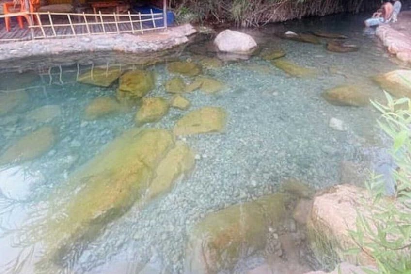 Un ruscello limpido con rocce e una recinzione in legno. 5