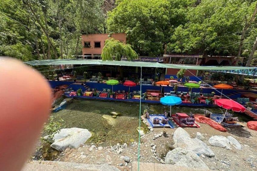 Un ristorante lungo il fiume con posti a sedere all'aperto e ombrelloni colorati. 2