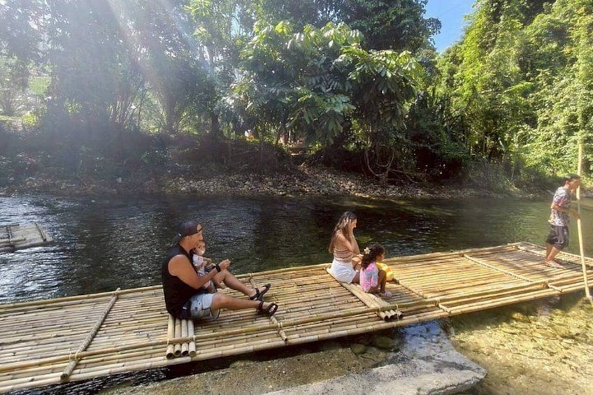 A bamboo raft on a river with people sitting on it. 4