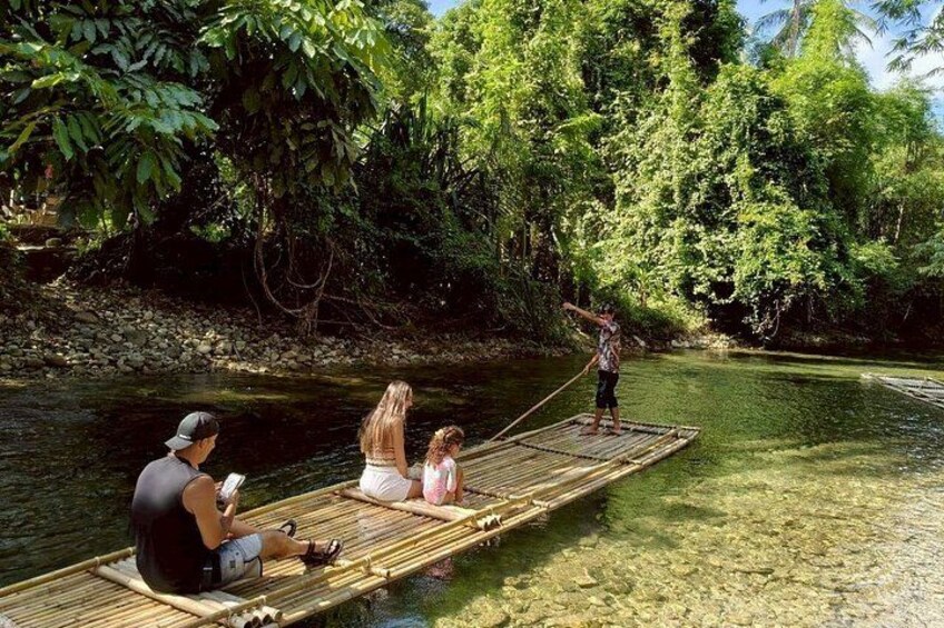 A river with a wooden raft carrying three people. 1