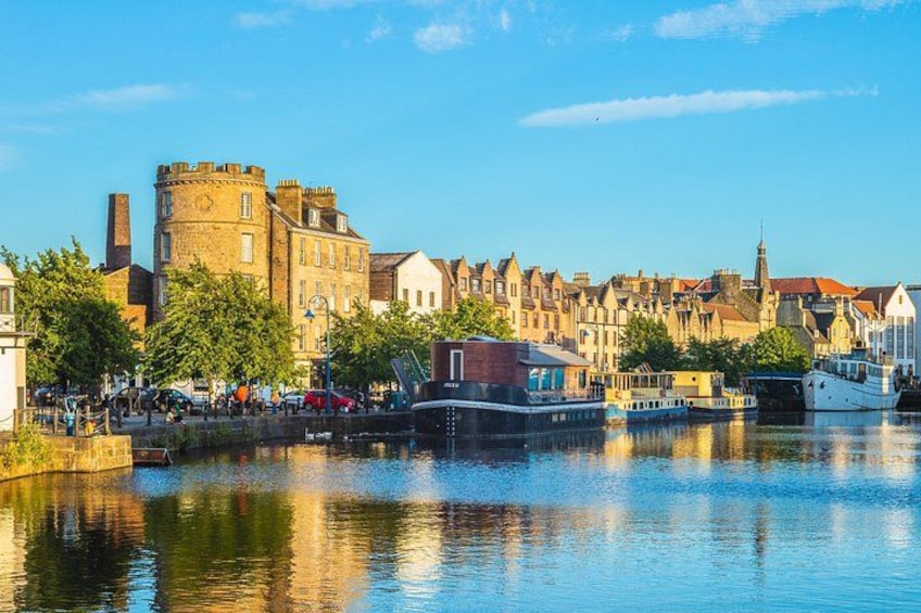 Un río con barcos, edificios históricos y un castillo. 3