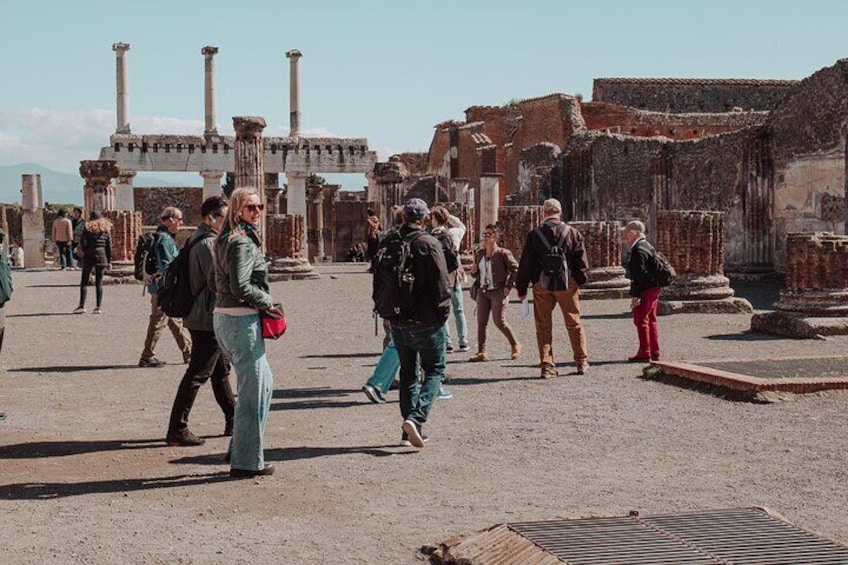 Tourists walking among ancient ruins with columns and arches. 5